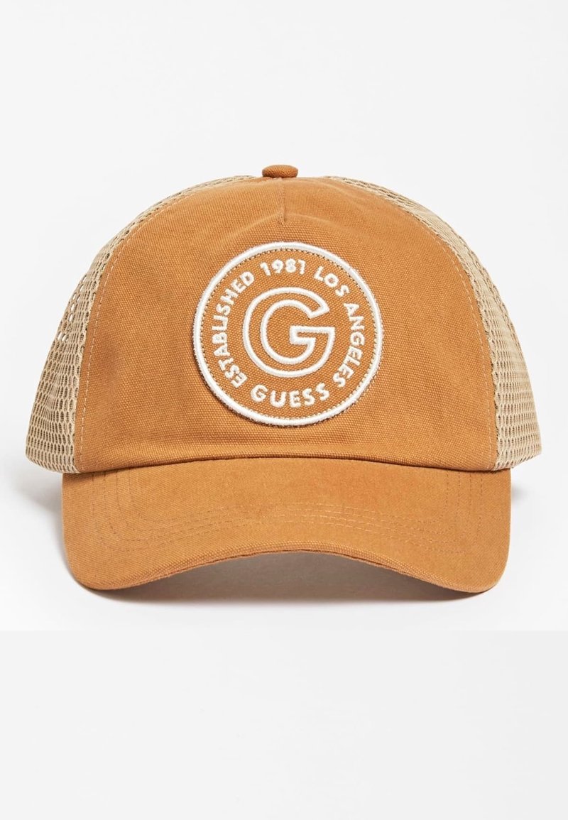 Casquette de baseball en mesh marron et beige avec un patch rond blanc indiquant "G GUESS Established 1981 Los Angeles" sur le panneau avant.