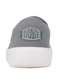 Szare trampki wsuwane z białą podeszwą, z okrągłym logo "HEY DUDE" na pięcie i akcentami w kolorze teal.