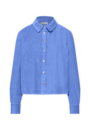 Pitkähihaiset siniset corduroy-paidat, joissa on terävä kaulus, edessä painonapit, hieman lyhennetty istuvuus ja resorit hihansuuissa.