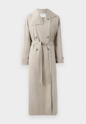 Lys beige lang trenchcoat med bred krage, dobbeltspente knapper, belted midje og mansjettstropper, vist flatt på hvit bakgrunn.