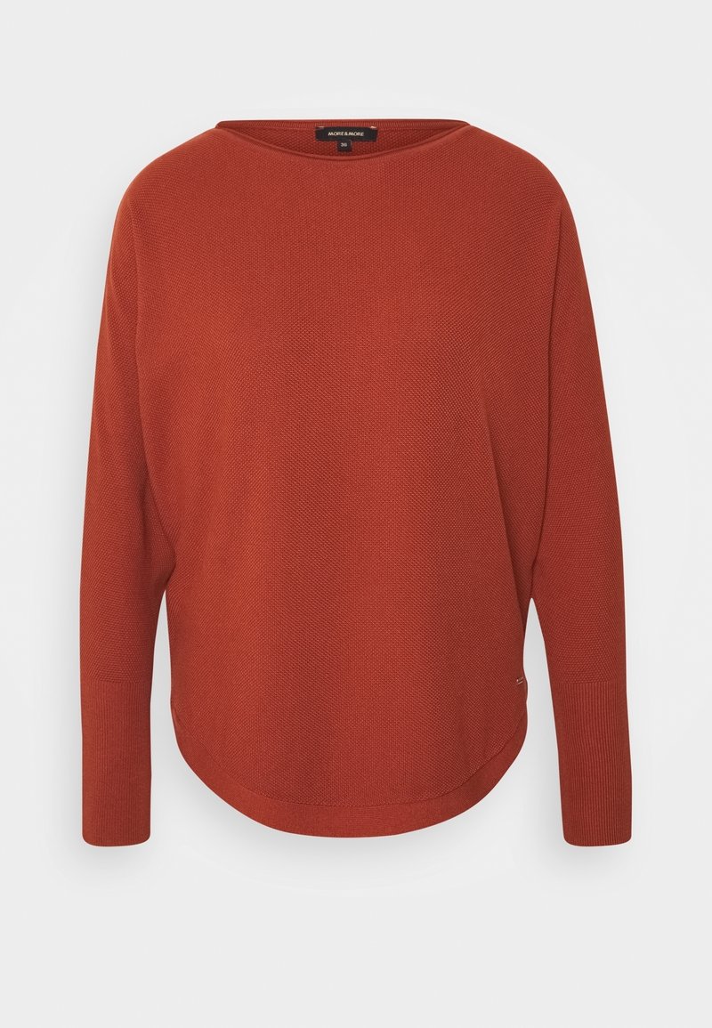 Pull en maille à manches longues couleur rouille avec ourlet arrondi et poignets côtelés, présenté sur fond blanc uni.