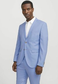 Light blue suit with notch lapels and two buttons, featuring a single chest pocket and matching trousers, worn over a white shirt.