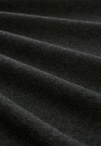 Czarna tkanina z miękką, teksturowaną powierzchnią z subtelnymi falami, podkreślająca jej gładkość i głębię, idealna do odzieży lub tapicerki.