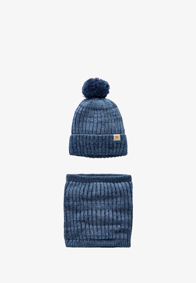 Niebieska dziana czapka z pomponem na górze oraz pasujący gruby komin z prążkowanym wzorem. Oba elementy mają teksturowany wzór.