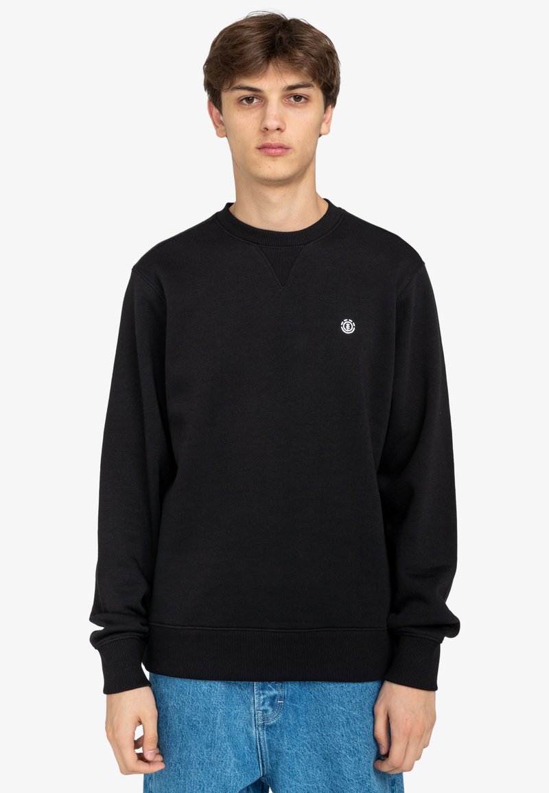 Svart sweatshirt med rundad hals och ribbade ärmslut. Har en liten vit logotyp på vänster bröst. Mjuk textur och löst sittande.