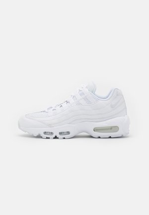 Biały sportowy tenis z siateczkową cholewką, widoczną amortyzacją powietrzną w podeszwie, bocznym logo Swoosh i zapięciem na sznurowadła, widoczny z lewego profilu.