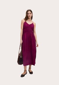 Mauve, sleeveless maxi dress with gathered texture at the bodice, paired with a woven brown bag and black flat shoes. Smooth fabric.