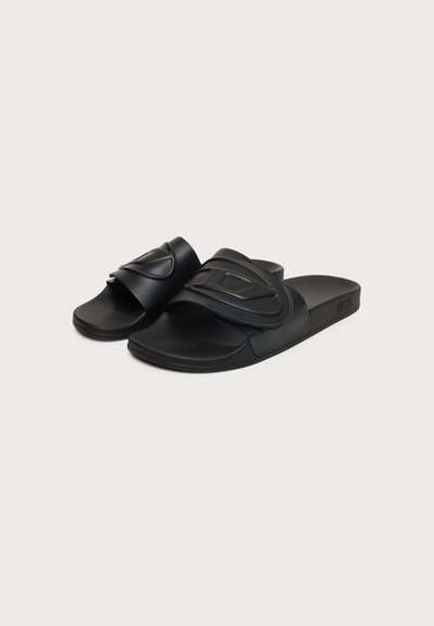 Paire de sandales noires à bout ouvert avec larges brides réglables présentant des motifs géométriques en relief sur un fond uni.