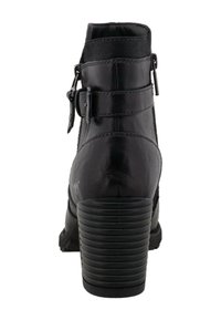 Bota de tobillo de cuero negro con parte superior texturizada, dos hebillas ajustables, puntera redondeada y un tacón robusto y estriado.