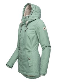 Manteau vert menthe avec une capuche doublée en fausse fourrure, poches à pression sur le devant, cordons de serrage réglables et un écusson circulaire sur la manche.