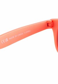 Occhiali da sole in plastica corallo con montatura rotonda, astine flessibili e lenti nere. Contrassegnati "CE UK CA MADE IN CHINA 7-10 ANNI."