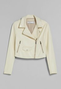 Króta kurtka motocyklowa z kremowej sztucznej skóry z wyciętym kołnierzem, srebrnymi zamkami błyskawicznymi i kieszenią na piersi. Gładka tekstura, minimalne przeszycia.