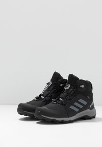 Czarne buty trekkingowe z siateczkową cholewką, gumową podeszwą i szarymi akcentami. Posiadają elastyczne sznurówki oraz wodoodporną membranę dla większej trwałości.