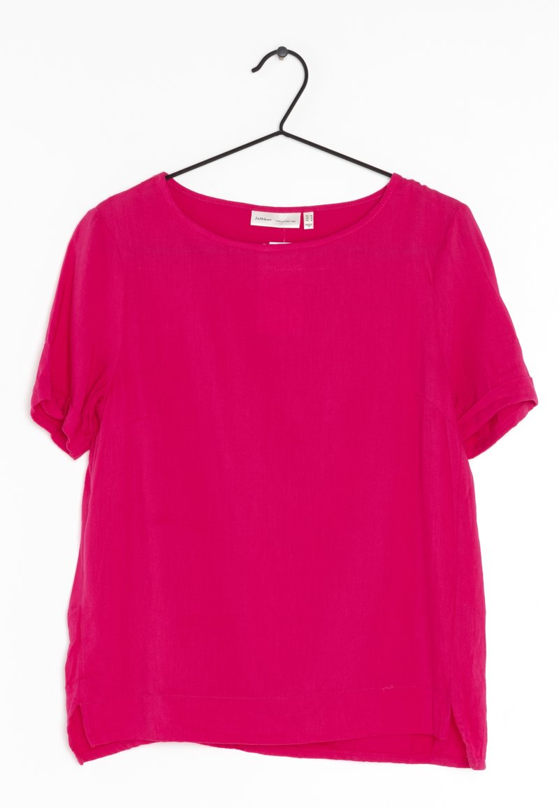 Krátký rukáv top v jasně růžové barvě. Vyrobeno z lehkého materiálu s kulatým výstřihem, bočními rozparky a ohrnutými manžetami.