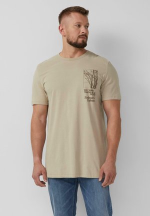 Beige kurzärmliges T-Shirt aus Baumwollmix. Enthält einen braunen Druck von Baumzweigen und Text auf der linken Seite. Standardpassform, Rundhalsausschnitt.