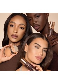 Three models showcase beauty products: a compact with a mirrored lid, a foundation bottle with a rose gold cap, and diverse skin tones.