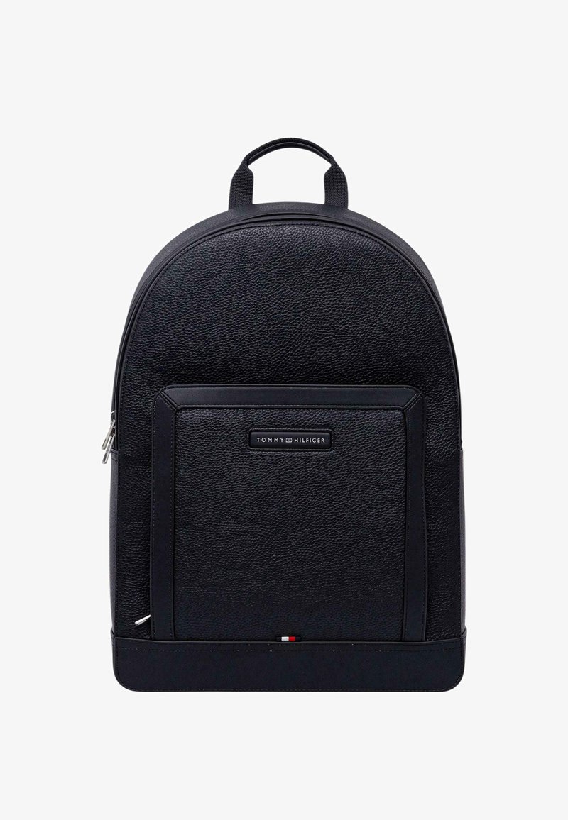 Sac à dos en cuir noir à forme arrondie, surface texturée, poche avant zippée et étiquette logo. Comprend une poignée supérieure et des bretelles réglables.