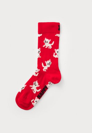 Red socks featuring a repeated pattern of small, playful white cats with pink accents. Black "HAPPY" text on the side. Made of knitted material.