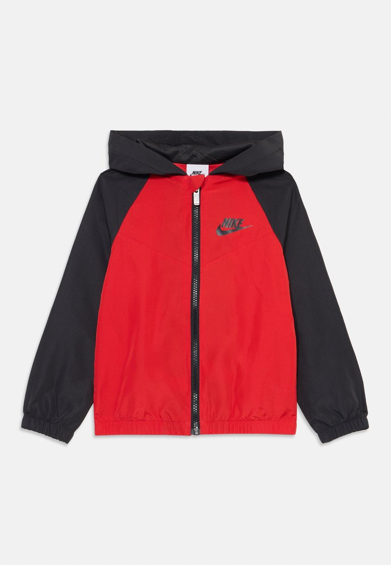 Abrigo cortaviento rojo y negro con capucha, cierre de cremallera y puños elásticos. Presenta el logo de Nike impreso en gris en la zona del pecho.
