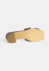Brown heeled sandal with a textured strap and smooth sole. Square toe design, featuring a slight heel and rubberized traction outsole.