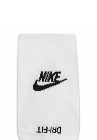 Calcetín blanco con textura acanalada, con un logo negro de Nike cerca de la parte superior y el texto "DRI-FIT". Diseño atlético clásico.