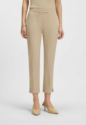 Pantaloni beige su misura con gamba dritta, caratterizzati da una texture liscia, spacchetti laterali all'orlo e un delicato dettaglio plissettato.