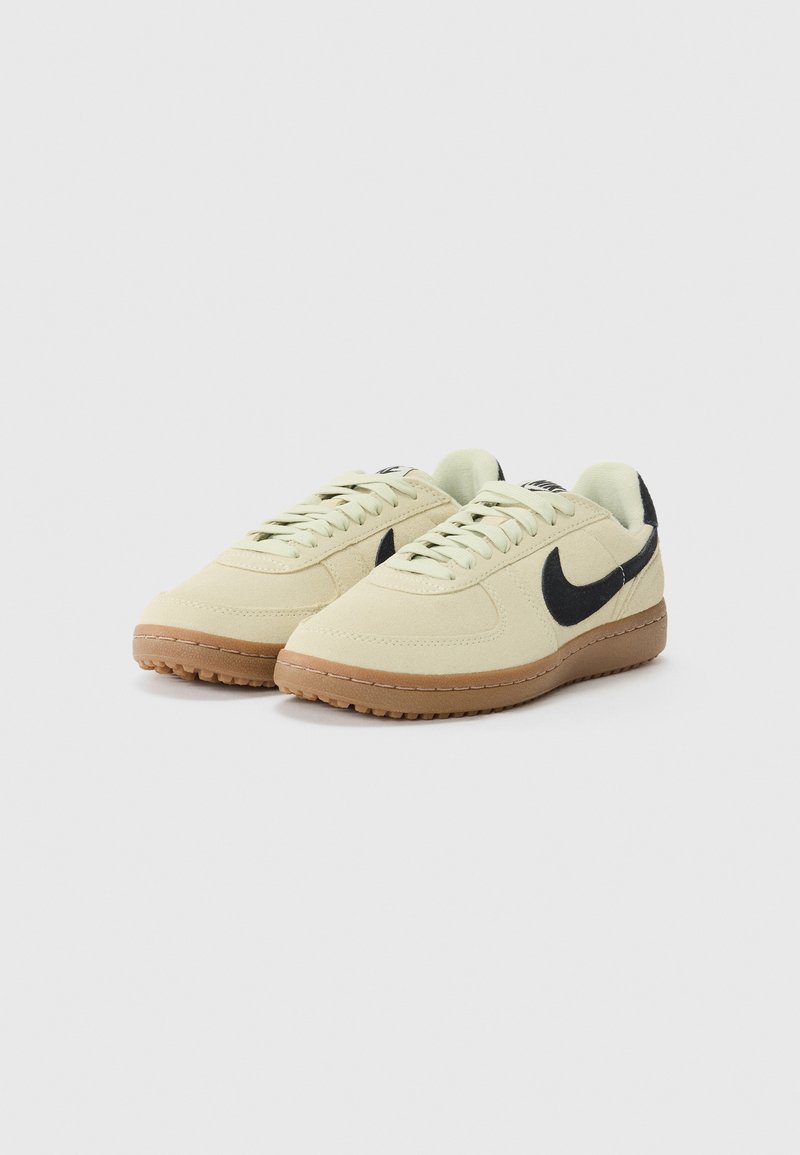 Baskets beiges avec une tige en suede douce, logo swoosh noir et semelle en gomme ; dotées de lacets ronds et d'un design minimaliste.