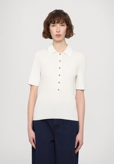 Bílý žebrovaný pletený polo top s krátkými rukávy, s knoflíkovým zapínáním vpředu a klasickým límcem. Hladká textura a přiléhavý střih.