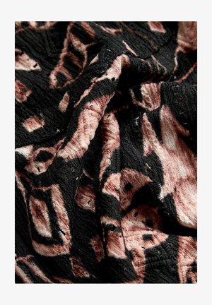 Tessuto testurizzato con uno sfondo nero e modelli astratti in rosa e beige; materiale morbido, intrecciato, con nervature e profondità visibili.