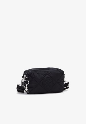 Black quilted fabric bag with a zip closure, featuring a round logo, silver hardware, and a detachable strap. Includes decorative charms.