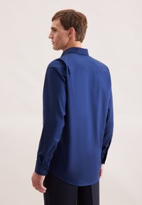 Blauwe overhemd met lange mouwen, een gladde textuur, klassieke kraag en knoopmanchetten. Heeft een recht achterontwerp en afgeronde zoom.
