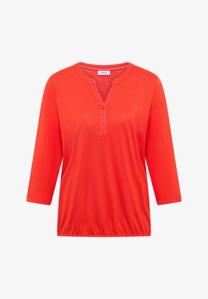 Chemise rouge vif pour femme à manches longues avec trois boutons au col en V et ourlet élastique, portant l'étiquette "CECIL" à l'intérieur du col.