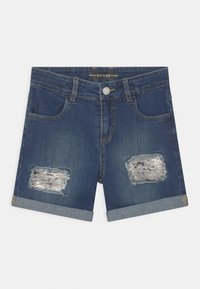 Pantalones cortos de mezclilla en azul oscuro con un diseño desgastado. Presenta dos bolsillos deshilachados con acentos plateados y un dobladillo plegado en la parte inferior.