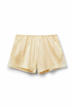 Kremowe satynowe szorty z elastycznym pasem i koronkowymi detalami po bokach, ułożone na białym tle.