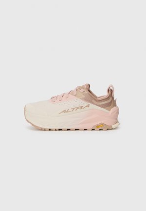 Chaussure de trail running avec une tige rose pâle et beige, texture en maille, accents réfléchissants et semelle extérieure Vibram pour une adhérence optimale.