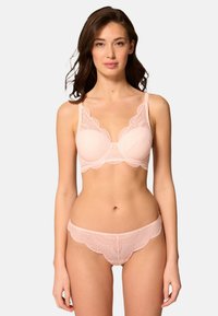 Ljust rosa spetsunderkläder set som innehåller en vadderad behå med vågiga kanter och matchande låghöjdsunderbyxor med dekorativt trim.