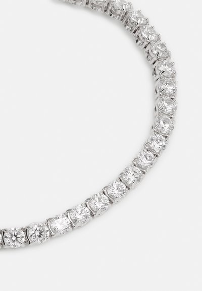 Bracelet en ton argent mettant en valeur des pierres de zircon cubique claires et rondes, serties dans des griffes, présentant un design à ligne continue.