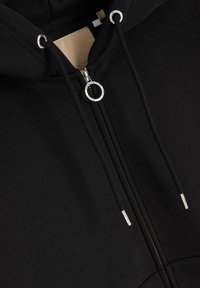 Czarny hoodie z zamkiem z przodu, okrągłym, srebrnym uchwytem do zamka i sznurkami. Wykonany z miękkiego materiału o gładkiej strukturze i minimalistycznym designie.