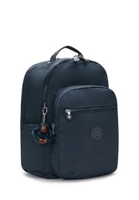 Zaino in nylon nero con due compartimenti con zip, tasca frontale, logo rotondo e un portachiavi a forma di scimmia in peluche attaccato.