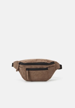 Bruine corduroy heuptas met twee zwarte ritsvakken en verstelbare riem op witte achtergrond.