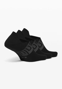 Musta matala varrella oleva sukka, jossa on ribbitekstuuri ja kuvioitu joustavyö harmailla yksityiskohdilla. Näytillä kolme paria.