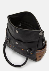 Czarna skórzana torba z dekoracyjnym haftem w kwiaty, zapinana na zamek błyskawiczny, z brązowymi akcentami. Posiada podwójne uchwyty u góry i pojemne wnętrze.