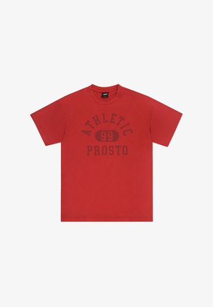 Czerwona bawełniana koszulka z krótkim rękawem, okrągłym dekoltem i ciemnym nadrukiem z napisem "ATHLETIC 99 PROSTO" w pogrubionej czcionce na przodzie.