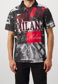 Czarno-biała koszulka polo z grafiką, na której widnieje czerwony napis "FORZA MILAN" oraz "A.C. Milan". Krótkie rękawy, kołnierzyk, teksturowany materiał.