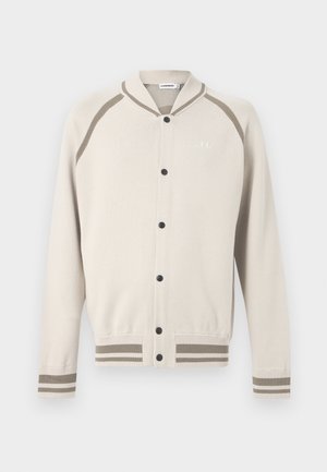 Cardigan boutonné crème avec des rayures taupe sur les poignets, l'ourlet et les épaules, présentant un petit logo brodé sur la poitrine.