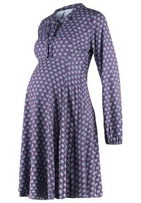 Mödraklänning i lila tyg med blommönster i blått och vitt. Har långa ärmar och en avslappnad silhuett. Snörning vid halsringningen.