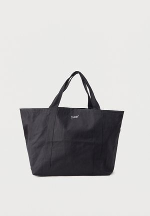Schwarze Stoff-Tragetasche mit zwei Henkeln und dem "TAION"-Logo mittig auf der Vorderseite vor hellem, einfarbigem Hintergrund.