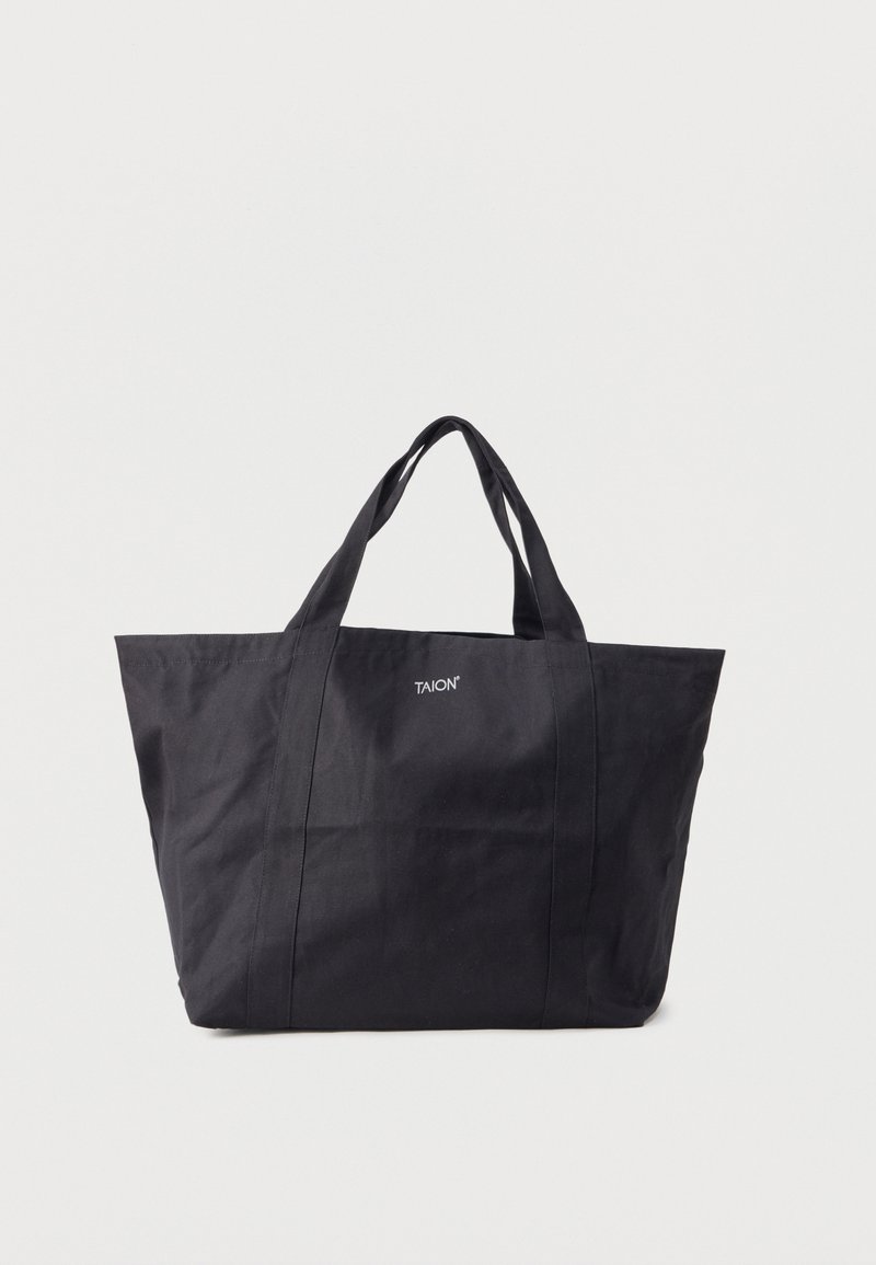Μαύρη τσάντα tote από ύφασμα με δύο χερούλια και το λογότυπο «TAION» στο κέντρο της μπροστινής πλευράς, με απλό φωτεινό φόντο.