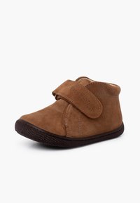 Bottine en suède marron avec une sangle velcro, bout arrondi, semelle en caoutchouc texturée et détails de couture subtils. Convient aux jeunes enfants.