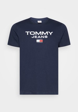 Granatowa bawełniana koszulka z krótkim rękawem z wyraźnym białym napisem "TOMMY JEANS" oraz prostokątnym logo z czerwonymi, białymi i niebieskimi elementami. Okrągły dekolt.